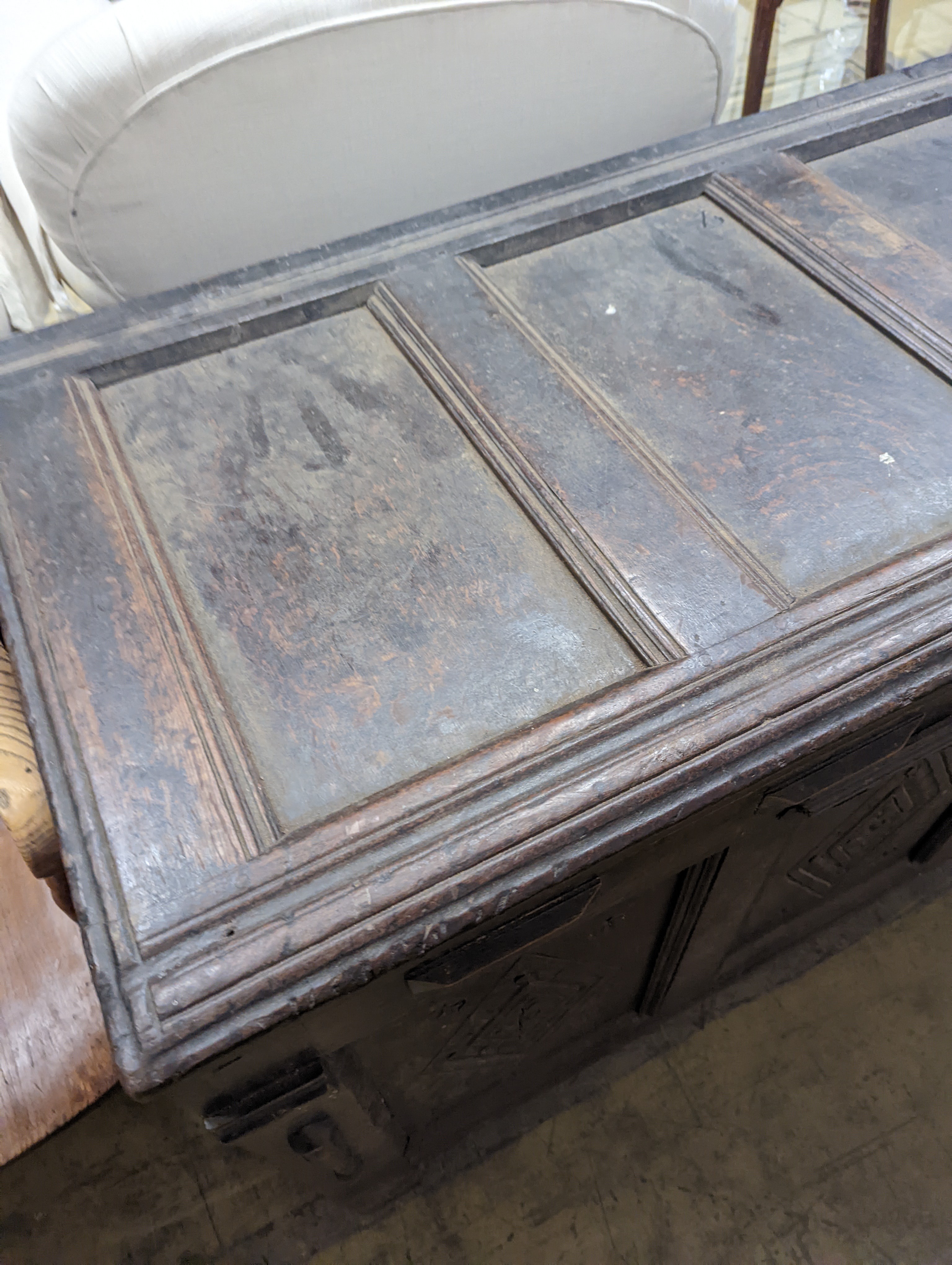 An early 18th century oak coffer, with four panel top and later carved and applied decoration, length 151cm, depth 63cm, height 76cm